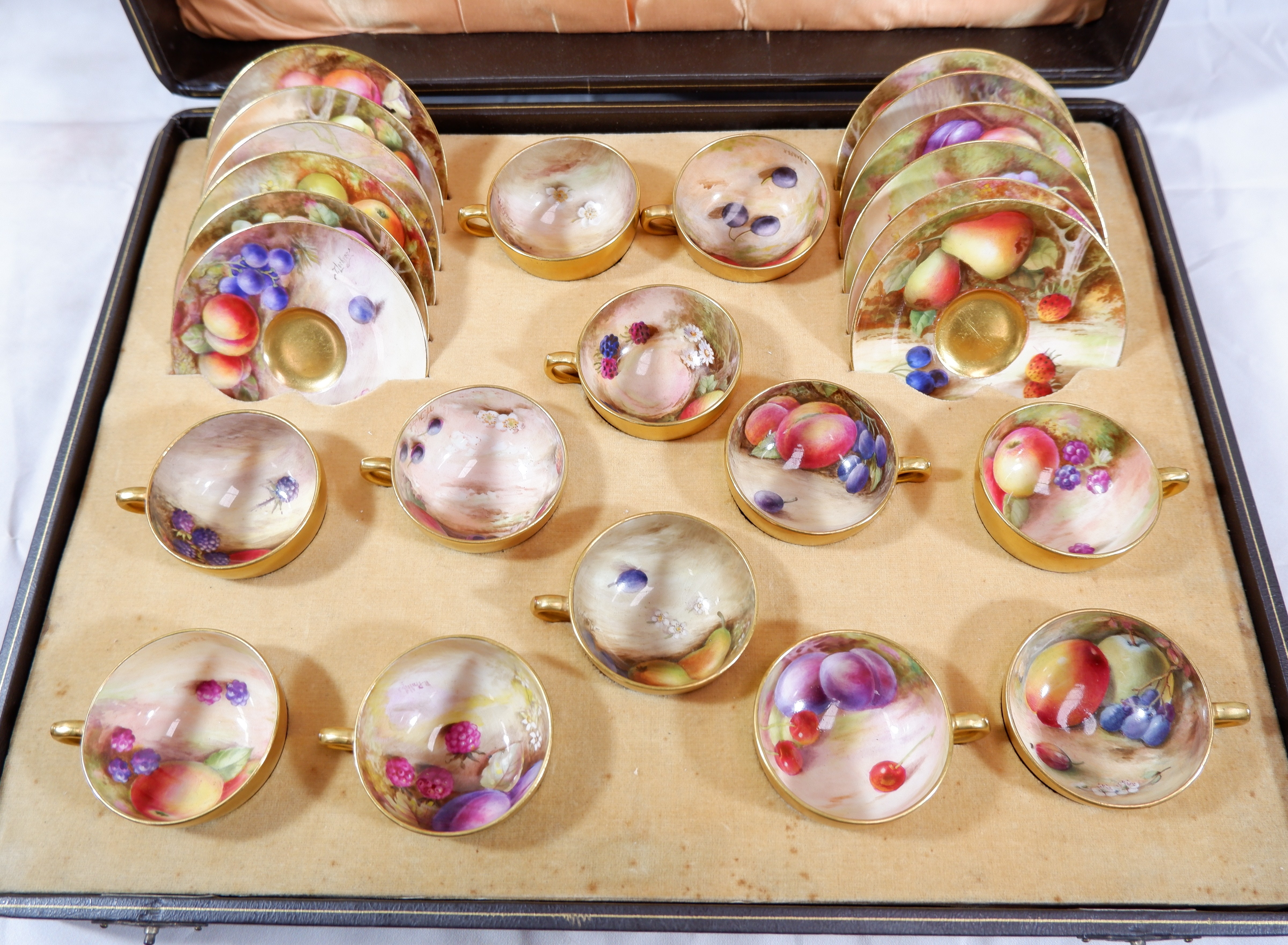 A set of Royal Worcester porcelain cabinet cups and saucers decorated with fruit on mossy banks,