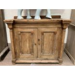 A stripped pine side cupboard with double doors, columns and bun feet