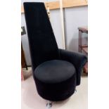 A high back chair upholstered in black on chrome feet