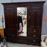 An Edwardian mahogany triple wardrobe with double hanging section and fitted section