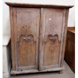 A Gothic style stripped oak cupboard with double doors and interior shelving, height 62", width 49"