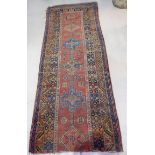 An early 20th century Middle Eastern hand knotted runner, brick red ground (one end missing)