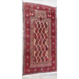 A red ground Middle Eastern prayer rug, 55" x 28"