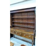 A 19th century joined oak dresser, the raised closed rack with three shelves over base with three