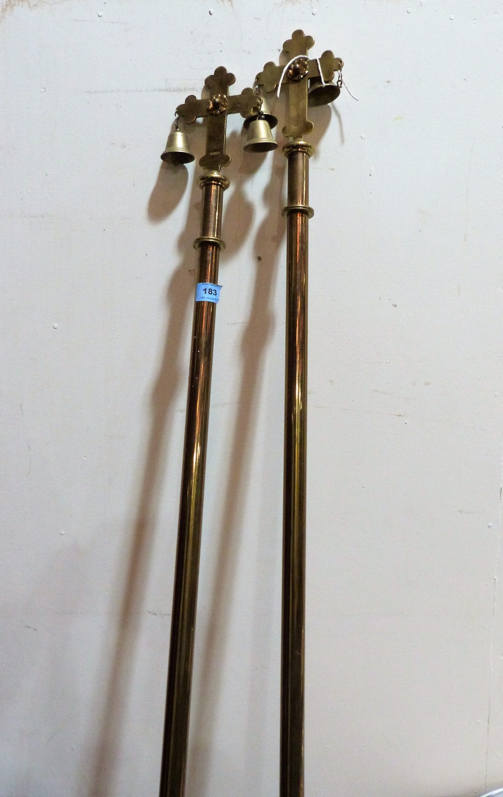 A pair of high church brass processional maces surmounted by a crucifix and bells. 85'' high