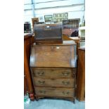 An oak bureau with three long drawers 28'' wide, together with a Singer sewing machine