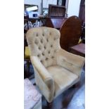 A Victorian deep buttoned armchair on turned legs