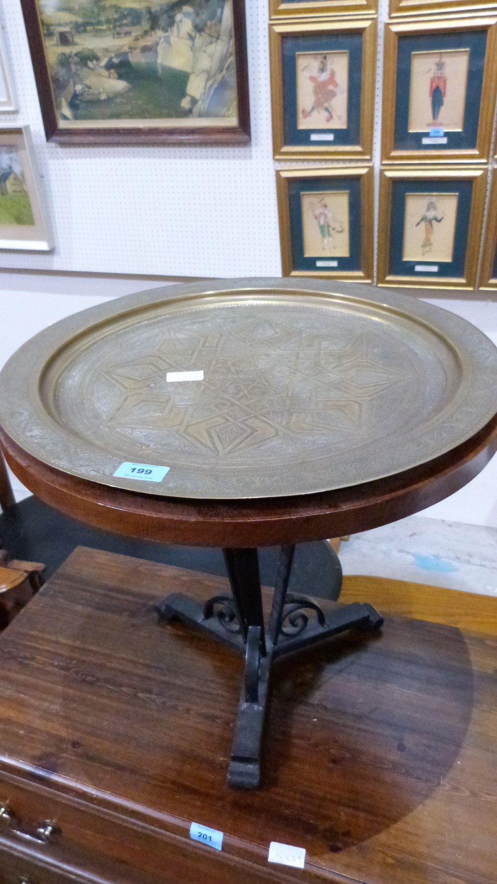 A wrought iron based occasional table with Benares type brass tray top