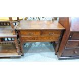 A joined oak lowboy with two short over one long drawer, on square legs with fan carved brackets.