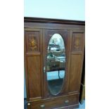 An Edward VII mahogany and line inlaid wardrobe enclosed by door with oval bevelled plate. 48''