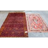 Two red ground eastern rugs, one with large hole to centre field