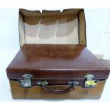 An early 20th century leather travelling case in original cloth protective cover. 18'' wide