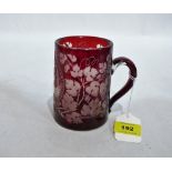 A 19th century German ruby glass mug, wheel engraved with a fox in reserve and trailing vine fruits.