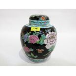 A Chinese jar and cover, painted with chrysanthemums, other flowers and prunus on a black ground.