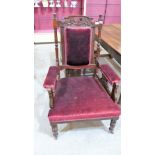 A late Victorian fireside chair upholstered in red velvet