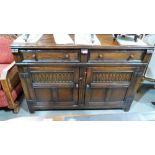 A 17th century style oak carved cupboard with two drawers on stiles. 48'' wide