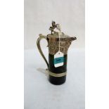 A Victorian green glass claret jug with plated mounts and lid with lion and shield finial. 9½''