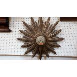 A 19th century French carved giltwood sunburst clock, the brass drum movement striking on a bell,