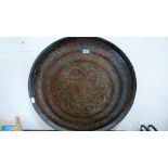 A Benares brass tray with geometric decoration and bands of foliage and text. 29' diameter