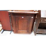 A George III oak hanging corner cupboard, the fielded door enclosing two shaped shelves