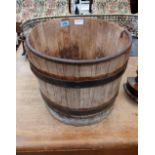 An oak coopered water pail with iron hoops and handle. 12' high