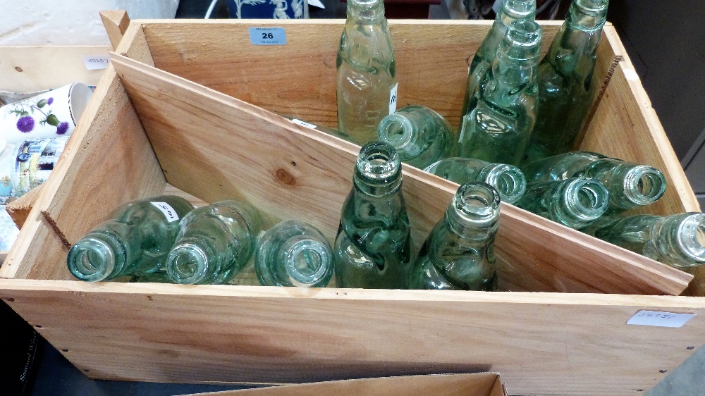 A wine box with 16 green glass bottles with marbles in necks