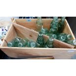 A wine box with 16 green glass bottles with marbles in necks