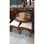 A pair of 1930's walnut bedroom chairs and an oval wall mirror with bevelled plate