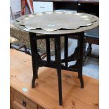 Two Benares brass tray tops on an oak folding base