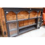 A carved oak dresser rack with three shelves and glazed cupboards flanking. 72'' wide