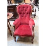 A Victorian mahogany spoonback parlour armchair upholstered in deep buttoned red velvet