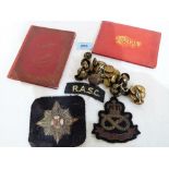 A collection of military brass buttons and badges, the lot including two booklets of views of
