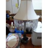 A table lamp with fabric and glass bead fringe shade