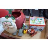 A tin plate Father Christmas plant holder, a clockwork tinplate monkey and a musical Christmas tin