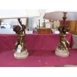 A pair of bronze ormolu table lamps cast as amorini on alabaster socle bases. 12½' high