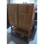 Reynolds of Ludlow. An ash cabinet enclosed by a pair of doors over a slatted shelf. 36' wide