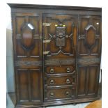 A 1930s oak bedroom suite comprising a triple wardrobe, two chests of drawers and a triptych