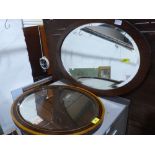 A crossbanded oval mirror with bevelled plate and a rosewood example