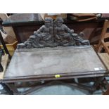 A Victorian oak hall seat, the raised back carved with putti and sea serpents. 37' wide