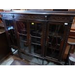 A 1930s oak bookcase enclosed by four astragal glazed doors on barleytwist supports. 60' wide