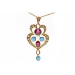 EDWARDIAN NINE CARAT GOLD GARNET AND SEED PEARL PENDANT openwork and set with an oval and a round