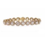 NINE CARAT GOLD GEM SET BRACELET formed by round white gem set floral clusters, 19.5cm long, 20.