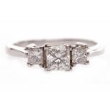 DIAMOND THREE STONE RING the central princess cut diamond of approximately 0.