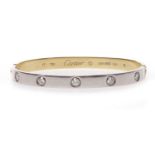 CARTIER EIGHTEEN CARAT GOLD BI COLOUR DIAMOND SET LOVE BANGLE formed by a yellow gold section with