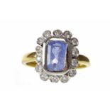 EIGHTEEN CARAT GOLD SAPPHIRE AND DIAMOND CLUSTER RING set with a central emerald cut sapphire 8mm