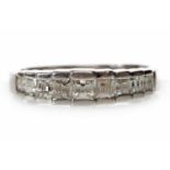 ART DECO STYLE PLATINUM DIAMOND RING set with graduated square step cut diamonds totalling