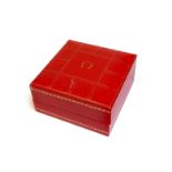 EARLY 1960S OMEGA RED LEATHER WATCH BOX with coffered decoration to the lid and gold dot highlights,