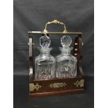 TWO BOTTLE TANTALUS wooden tantalus with two crystal decanters,