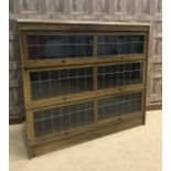 MAHOGANY THREE TIER DWARF BOOKCASE enclosed by three leaded glass 'up and over' doors,