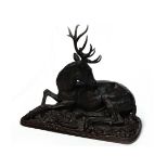 BRONZE SCULPTURE OF A STAG modelled recumbent, on an naturalistic oblong base,